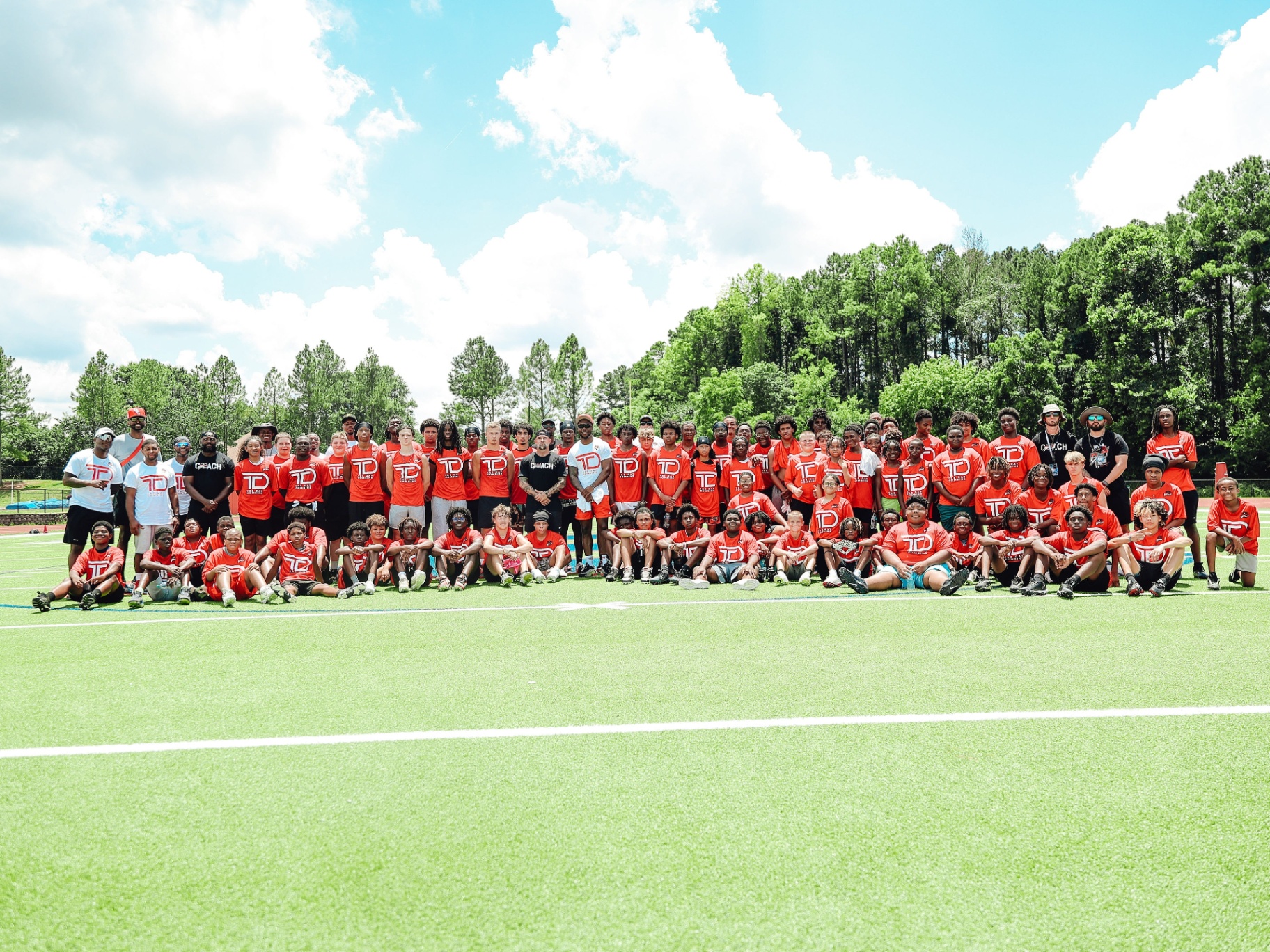 Group photo of every camp athlete and coach on the field